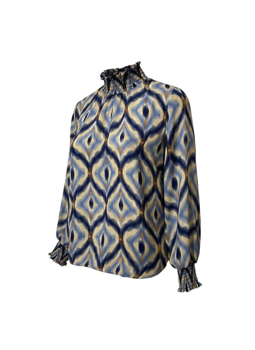 Blouse Martina Devï Studios SARL bleue et beige à motif abstrait, col montant froncé et poignets élastiqués, 70% soie, 30% viscose.