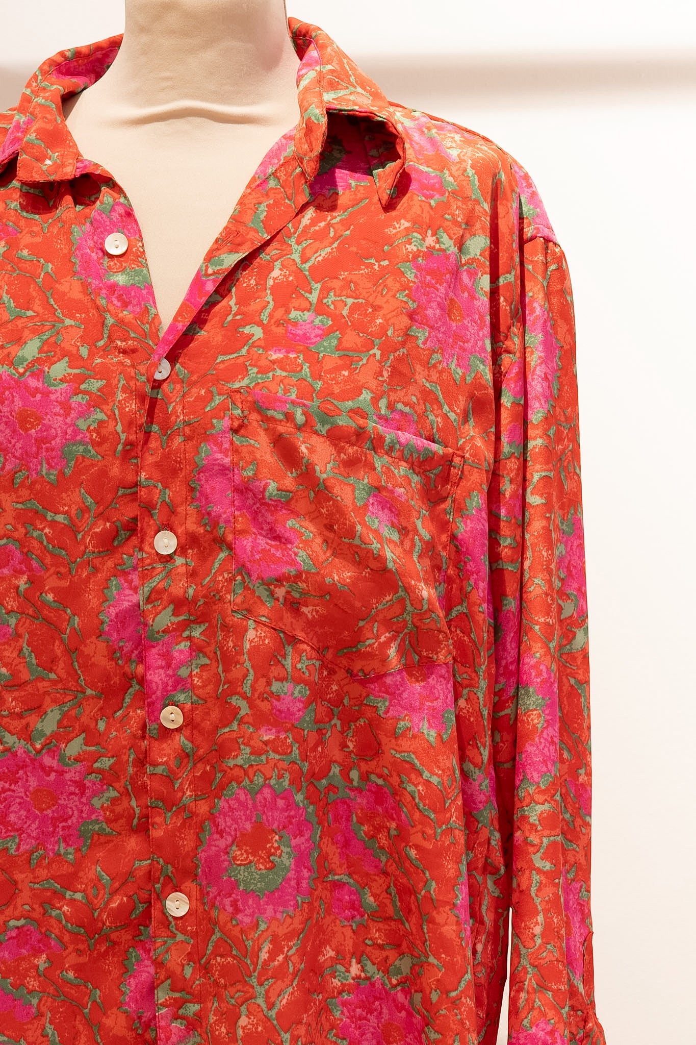 Chemise oversize Devï Studios SARL en soie et viscose, motif floral abstrait rouge et rose, col à revers, boutonnée.
