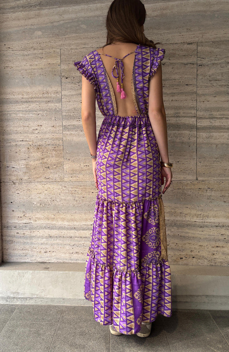 Robe longue Devï Studios SARL violette et dorée, en soie et viscose, avec un dos nu et des pompons roses.