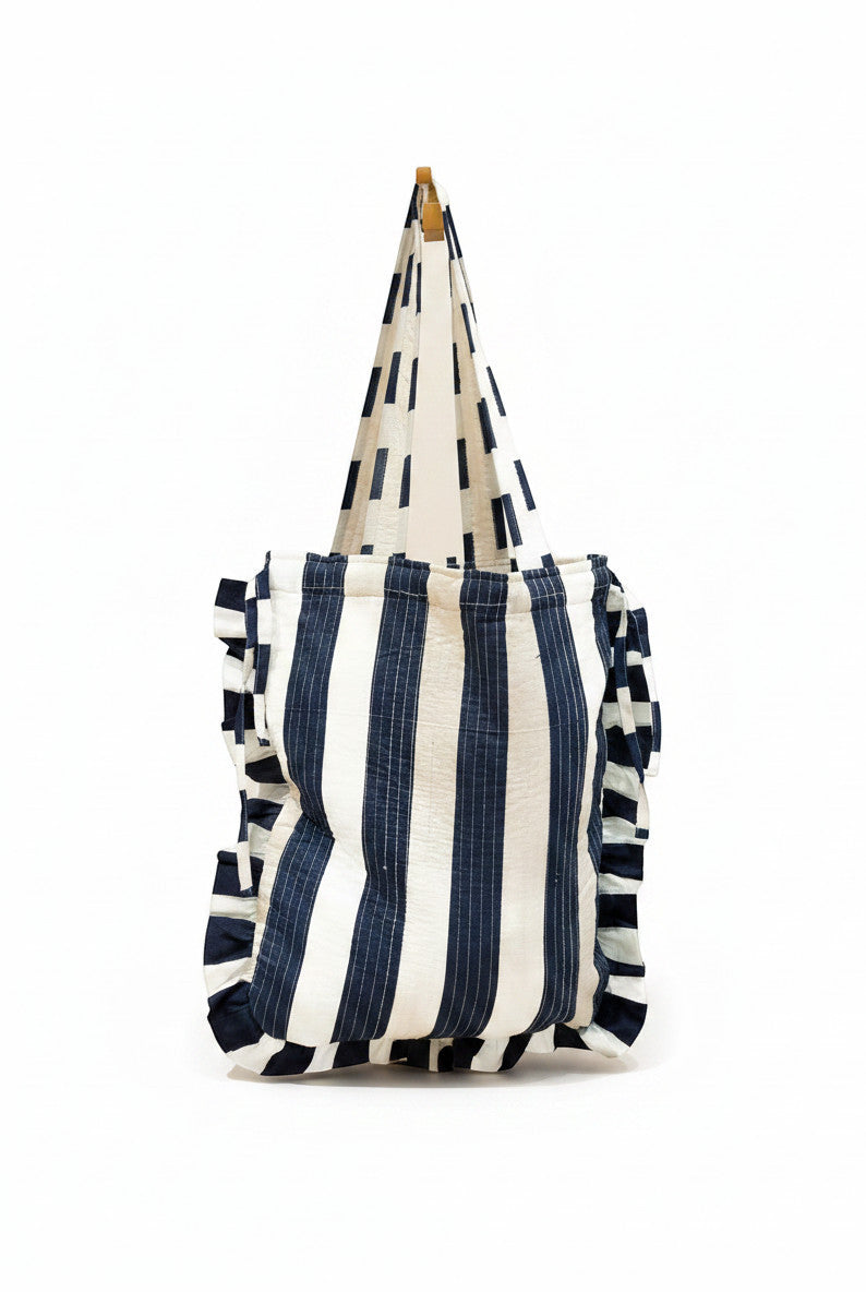 Sac fourre-tout en coton rayé bleu marine et blanc, avec fermeture à cordon réglable. Par Devï Studios SARL.