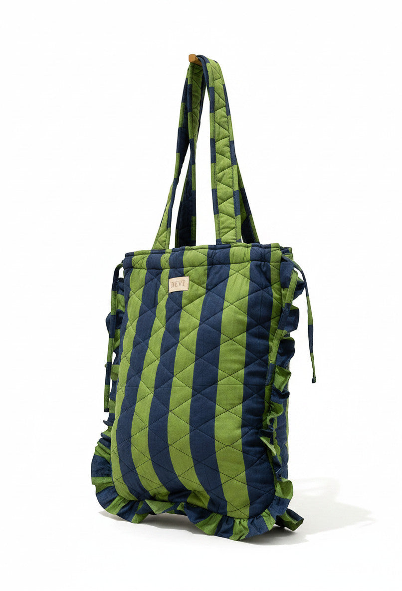 Sac fourre-tout en coton matelassé Devï Studios SARL rayé bleu marine et vert avec volants sur les côtés et fermeture à cordon.