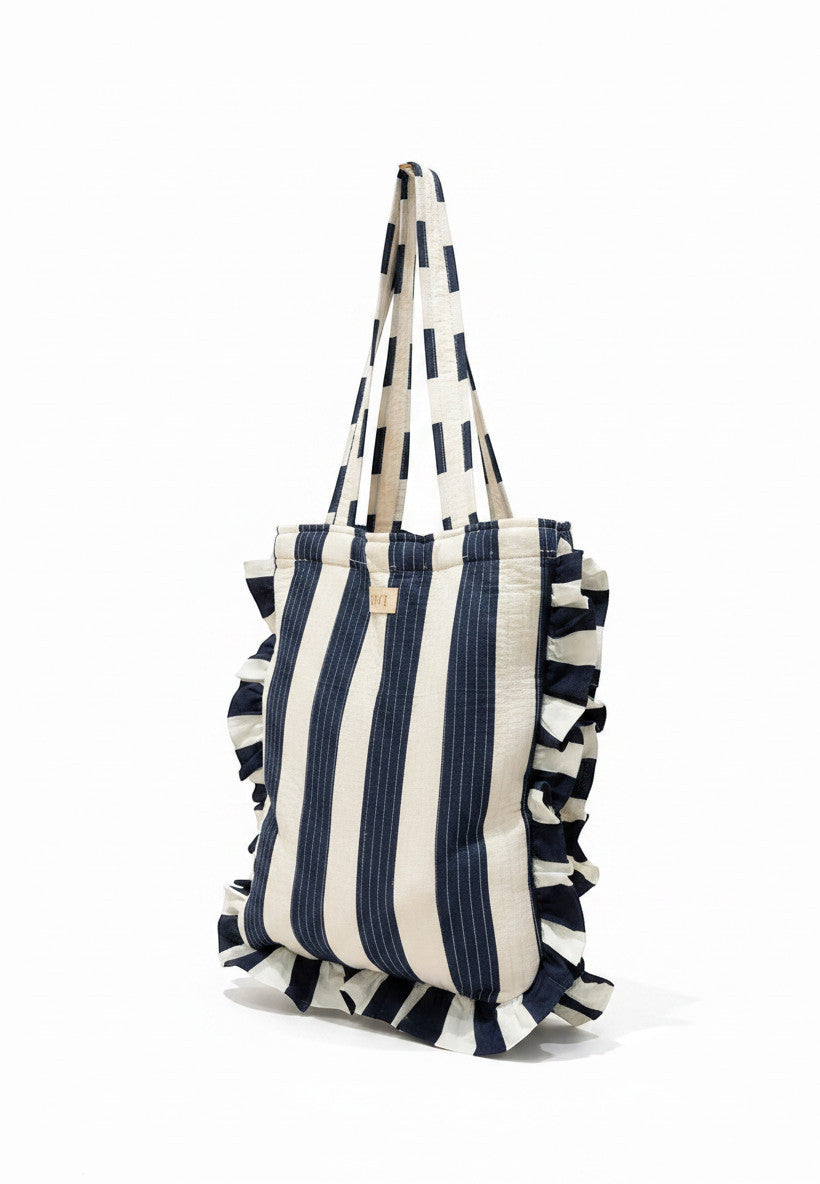 Sac fourre-tout en coton Devï Studios SARL rayé bleu marine et blanc avec volants, idéal pour le shopping ou la plage.