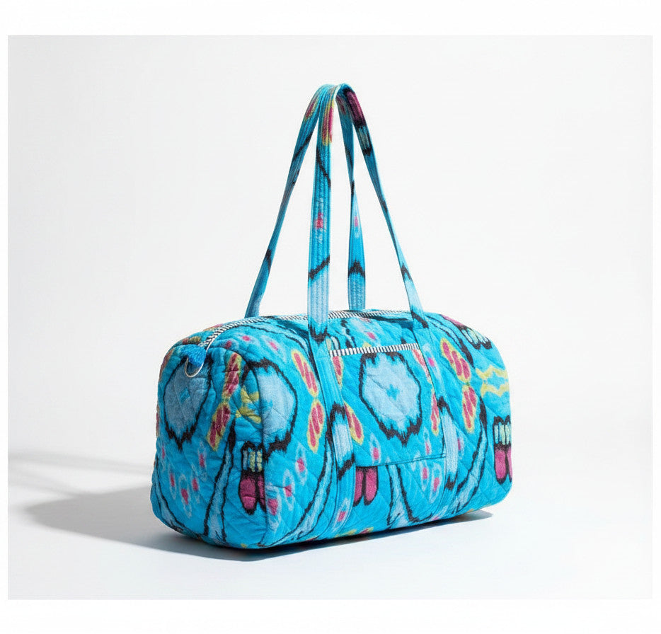 Devï Studios SARL sac de voyage bleu vif en velours et coton matelassé avec un imprimé abstrait coloré, idéal pour le week-end.