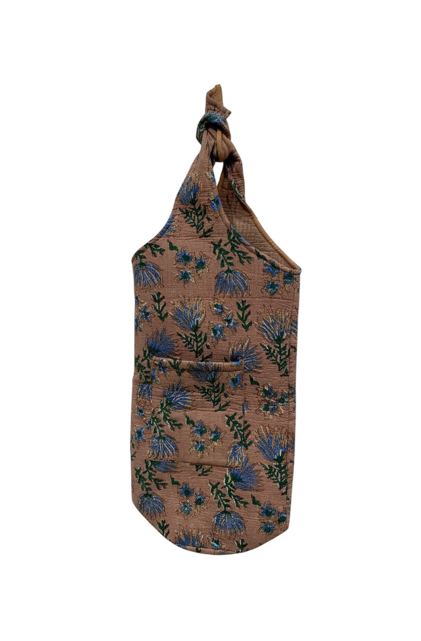 Sac de yoga Devï Studios SARL en coton rose pâle avec imprimé floral bleu et vert, poche avant et anse nouée.