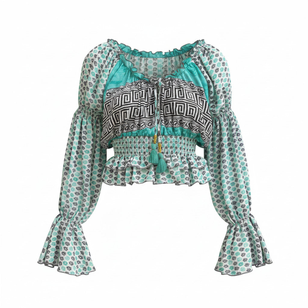 Top Sari Nora Devï Studios SARL en tissu upcyclé, manches longues bouffantes, col froncé avec liens, imprimé ethnique turquoise et noir.