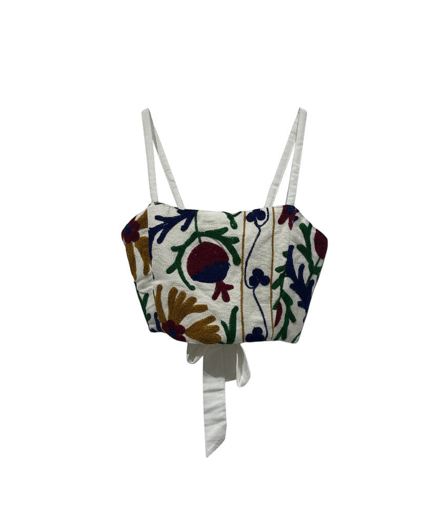 Devï Studios SARL top Pipa en coton blanc brodé de motifs floraux multicolores, style bandeau ajustable.